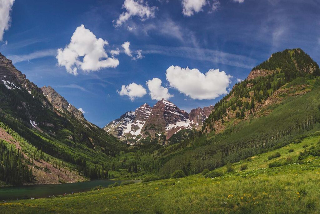 Majestic Maroon Bells peaks and Maroon Lake on a sunny day and blue sky in summer near Aspen, Colorado