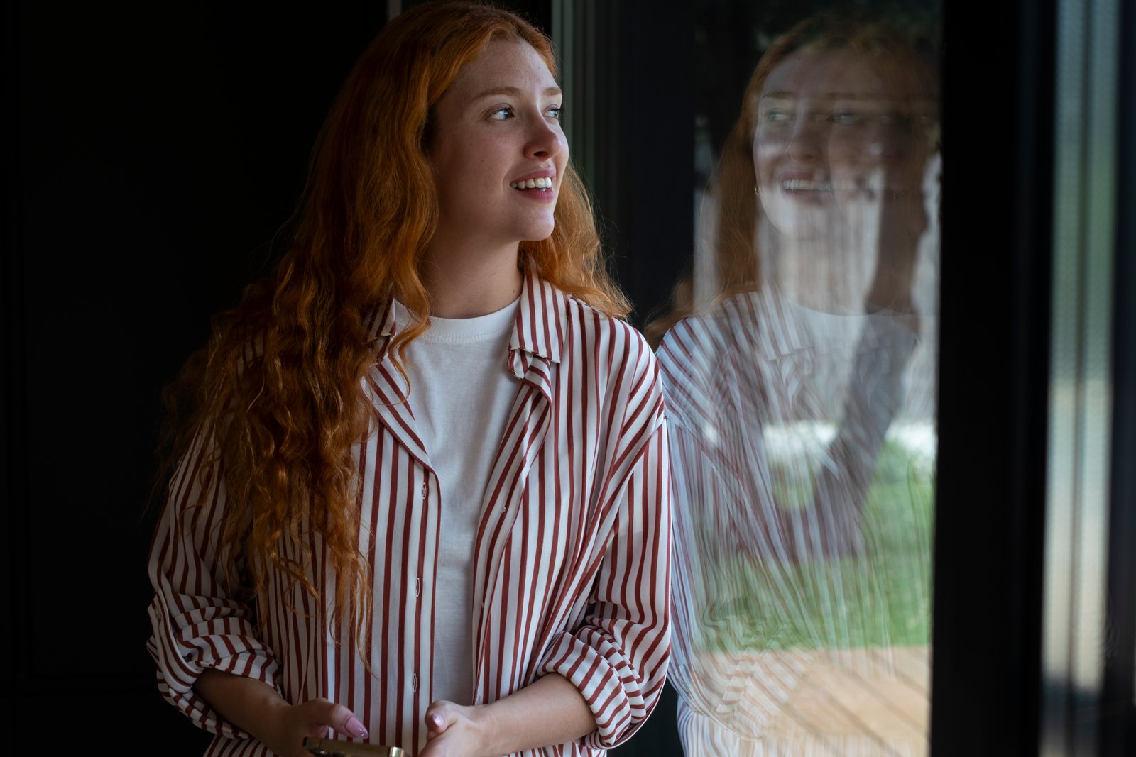 Woman reflecting by a window during alcohol rehab in Colorado.