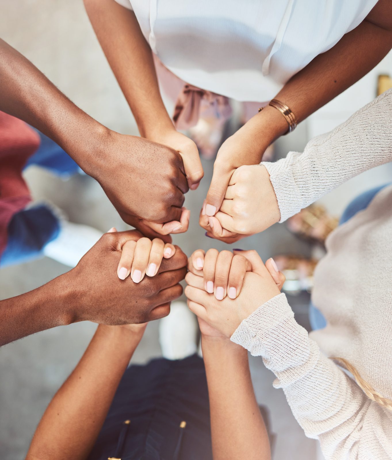 Diverse hands joined together in support, symbolizing community and mental health recovery for women